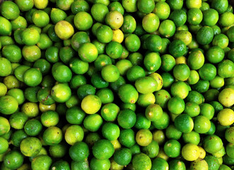 Vibrant Fresh Green Lemons in a Basket for Market Sale