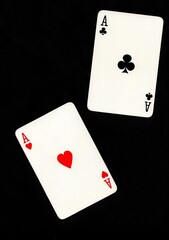 A pair of playing cards of the same value isolated on a black background.