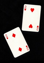 A pair of playing cards of the same value isolated on a black background.