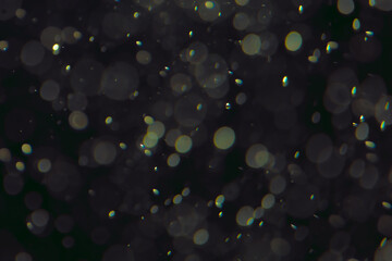 Defocused bokeh lights in various sizes and colors on a dark background creating a dreamy and abstract visual effect