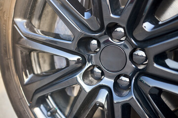 Alloy wheel plug and brake caliper selective focus close up.