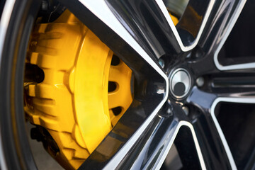 Car detailing. Aluminum wheels with Yellow Brake Calipers selective focus closeup shot.