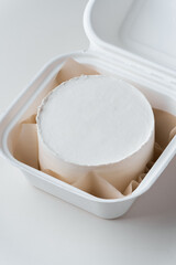 Clean white little bento cake without decoration in a gift box with brown paper inside. Cake mockup with a free space for your own decoration on the white marble background