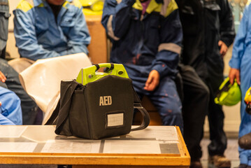 Focused shot of an AED, a vital link in survival, during emergency training of the crew on a cargo ship.