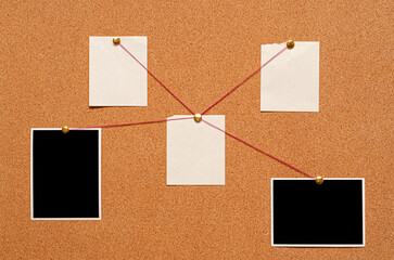 Blank paper notes and an empty photo are pinned to a cork board. The concept of detective...