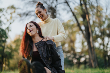 Fototapeta premium Two women are depicted having fun and laughing together in a tranquil park setting, enjoying the serene beauty of nature and cheerful company.