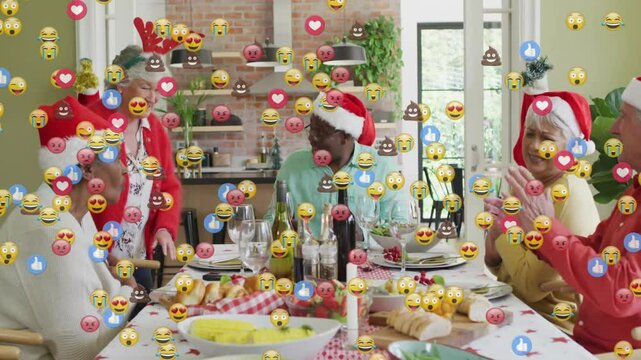 Senior friends celebrating holiday marketing around dinner table, with floating emoji reactions