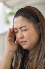 Fototapeta premium Unwell middle age woman having migraine type headache, pain at one side of the head problem, concept image for physical and mental health care