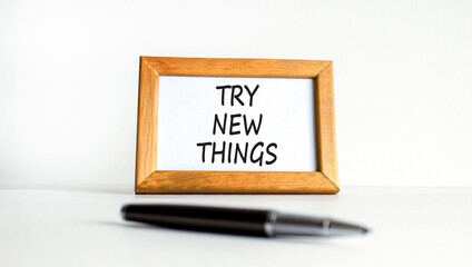 Try new things symbol. Concept words Try new things on beautiful wooden picture frame. Black pen. Beautiful white background. Business motivational lifestyle try new things concept. Copy space.