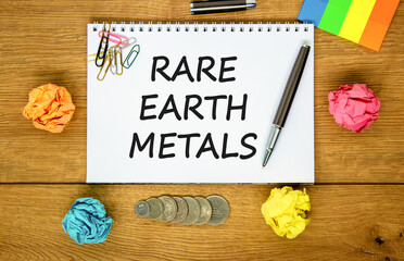 Rare earth metals symbol. Concept words Rare earth metals on beautiful white note. Black pen. Colored paper. Beautiful wooden background. Business and rare earth metals concept. Copy space.