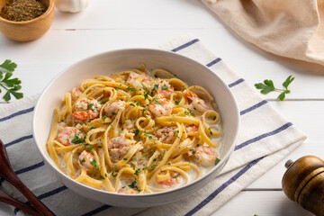 Fettuccine pasta with shrimp in white cream sauce.Creamy Shrimps Spaghetti carbonara sauce in white plate.