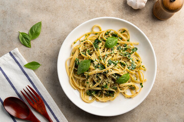 fettuccine pasta with kale walnut pesto sauce in white plate.Top view.