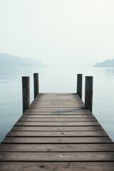 Fototapeta premium Serene Wooden Dock Extending into a Misty Lake, a Path Leading to Tranquil Waters