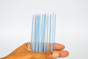 several straws in hand on white background