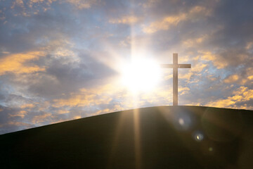 Cross against beautiful sunset over the mountains, christianity and religion concept