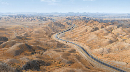 Fototapeta premium Aerial view of winding road through vast desert hills, showcasing beauty of arid landscapes and natural formations