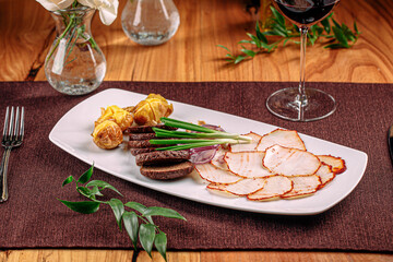 Portion of appetizer with smoked slices of salo and bread