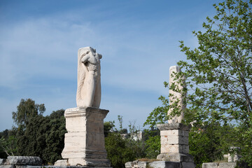 Obraz premium Ancient Greek statues located in the Ancient Agora, in the center of Athens, Greece, against a blue summer sky