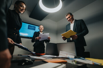 A group of professionals conducting a meeting in an office, discussing documents and charts. The...