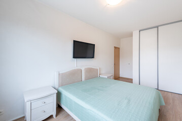 Modern Minimalist Bedroom With Television and Soft Blue Bedding