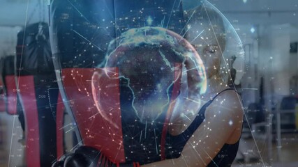 Female boxer training with boxing bag in gym showing fitness data with digital graphics and globe - Powered by Adobe