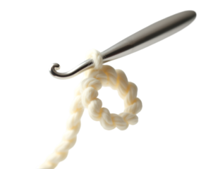 Close up of a shiny silver crochet hook with a partially formed loop of creamy colored yarn on a surface showcasing the art of needlework