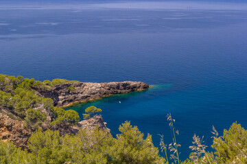 Soller, Balearic Islands, Spain An incredible view of the turquoise sea and rock point with a bird flying in the distance