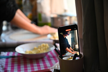 Filming on a phone as a girl cooks pizza. Home shooting. Video content for social networks.