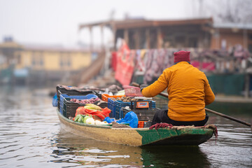 Obraz premium Low depth of field shot showing floating vegetable vendor on shikara boat on the calm waters of Dal lake Srinagar Kashmir