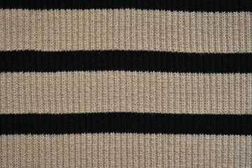 striped pastel black texture of woolen knitted fabric as a background, striped pastel black texture of smooth symmetrical lines of synthetic fabric 
