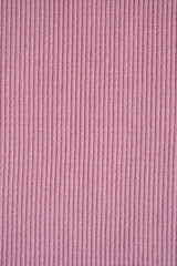 Fototapeta premium pink texture of knitted synthetic fabric as a background, pink smooth symmetrical lines of synthetic fabric 
