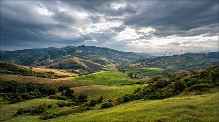 Naklejka premium Scenic mountain valley landscape with rolling hills, pastures, and wind turbines