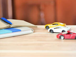 Notebook and car on the desk. Car insurance and financial business concept.Copy space.