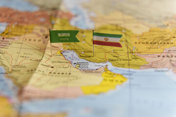 Naklejka premium Mini flags of Saudi Arabia and Iran pinned on a map showing the Persian Gulf region