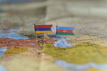 Mini flags of Armenia and Azerbaijan pinned on a map, symbolizing political tension and conflict over borders