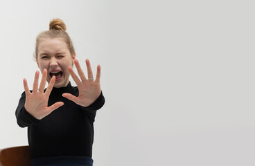 A screaming young girl repels something with her hands. The woman is afraid of somebody. An...
