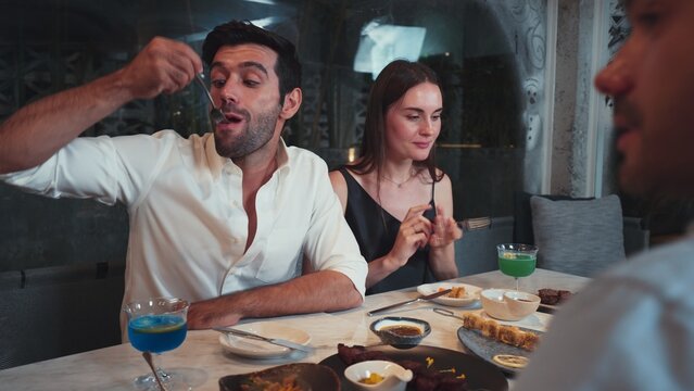 Delicious tasty food served couple and friends at luxurious cuisine dinner. Smart man tasting crispy dishes with enjoying memorable eating experience dining out enhance evening restaurant. Vinosity.