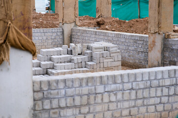 Construction site with stacked bricks and foundation walls