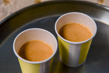 Warm beverages served in paper cups on a metal tray