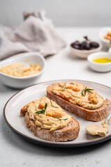 Delicious sandwiches with hummus and ingredients on white table, flat lay. High quality photo
