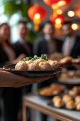 A woman's hand delicately holds a plate of dumplings, Asian cuisine.