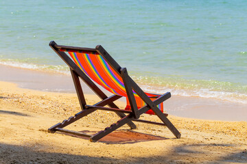sun beach chairs on shore near sea.