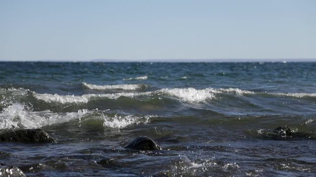 Big slow motion waves rolling into rocky shore in early evening, Lake Superior, Duluth, Minnesota, United States