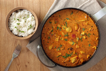 cardamom butter chicken in pan, rice.
