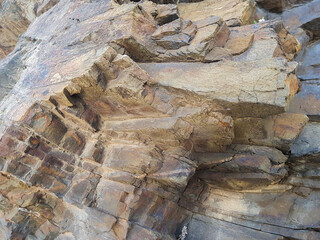 The rock formation features intricate textures and layered structures, illuminated by bright sunlight. This geological marvel highlights natural erosion and weathering over time