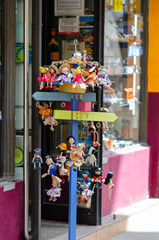 Obraz premium March 27 2022 - Spain. A charming assortment of handcrafted wooden dolls is showcased outside a vibrant souvenir shop, creating a cheerful street market atmosphere. Perfect for tourism concepts.