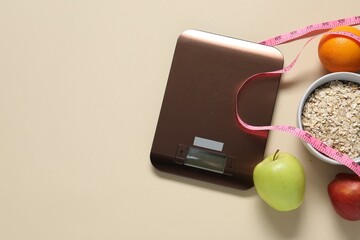 Electronic kitchen scale, measuring tape and products on beige table, flat lay. Space for text