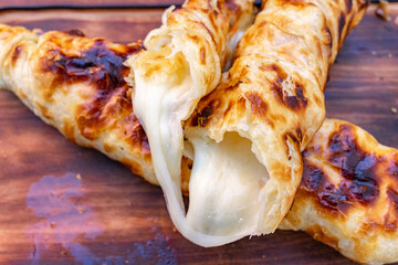 Freshly baked cheese pastries with golden crust on wooden board