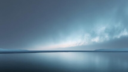 Obraz premium Landscape photograph of a vast body of water. the water is calm and still, reflecting the sky above. the sky is a deep blue with a few wispy clouds scattered across it.