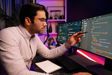 Working smart IT developer pointing data software development on two pc screen, creating...